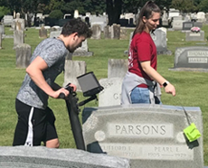 Man and Woman cleaning the headstones at the Parsons Cemetery