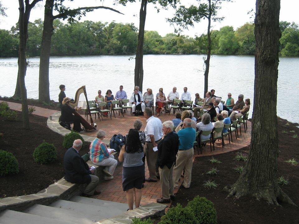 Group of people gathered around a harpist at the Parsons Cemetery